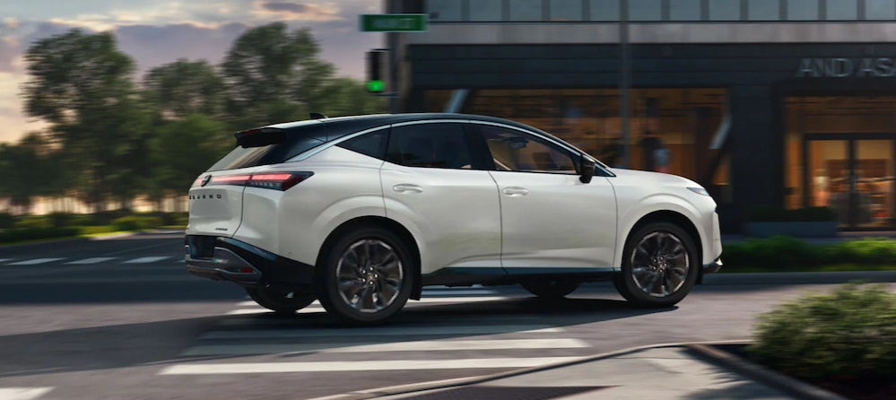 A white 2026 Nissan Murano SUV turning a corner on a city street
