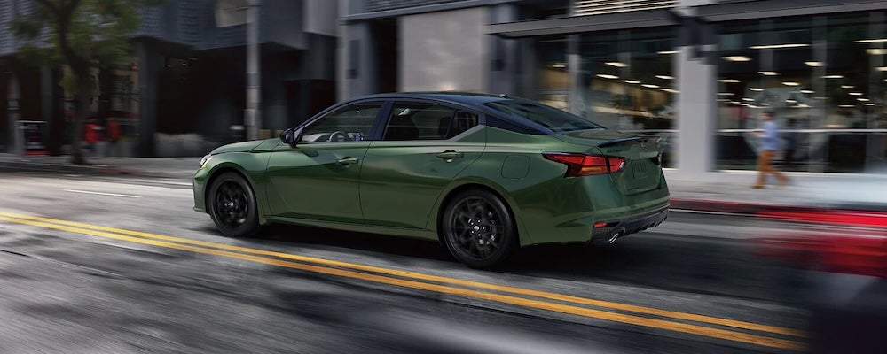 A green 2026 Nissan Altima sedan driving down a city street