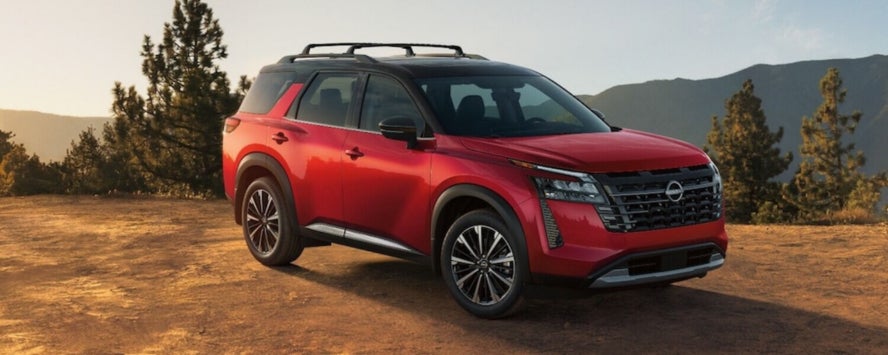 A red 2026 Nissan Pathfinder SUV parked on a mountain ledge